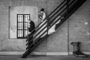 La sposa scende le scale con il padre alla Tenuta Castello di Cerrione.